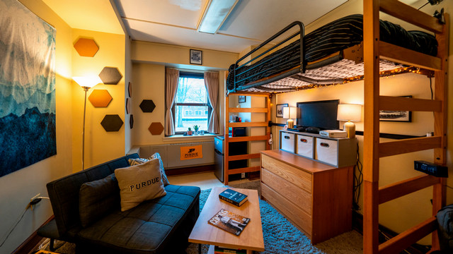 A furnished room with several Purdue themed items.