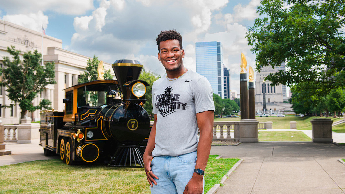 A student standing outside in front of the Boilermaker Special
