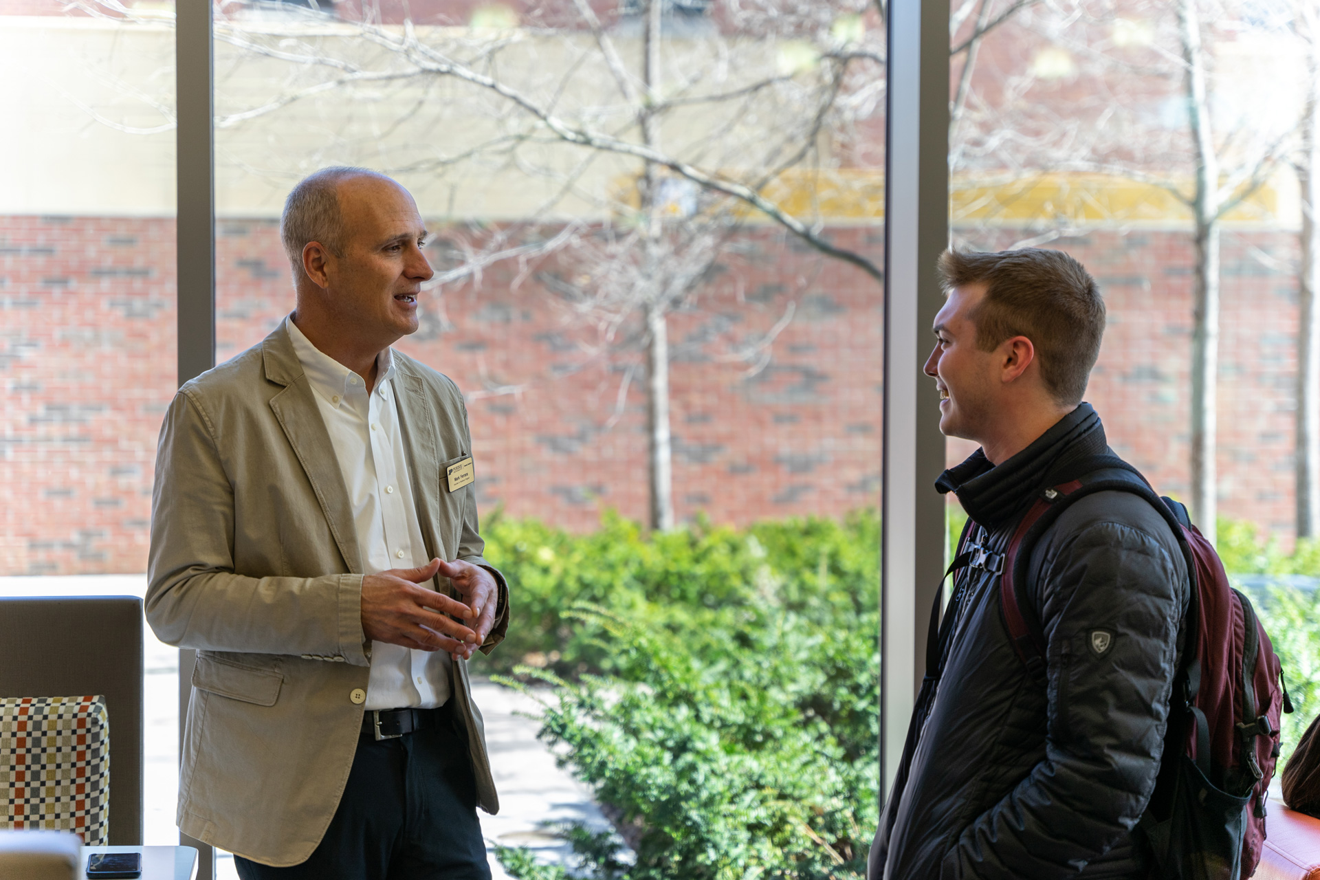 Executive-in-Residence Mark Ferrara greets a student at a Coffee and Consulting session.