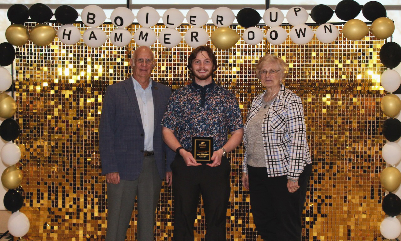 Spencer Gregar-Skillman holds award with Bill and Barbara Rakosnik