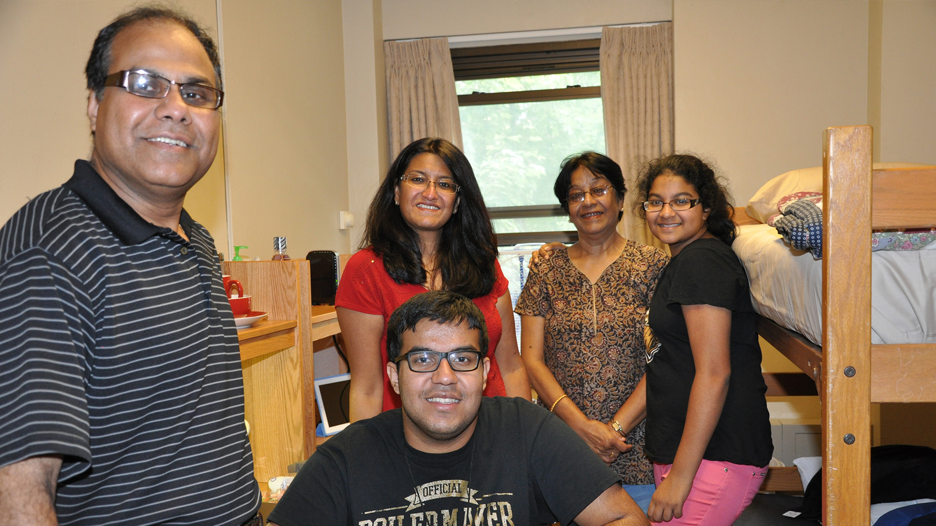 A Purdue family posing for a photo in their student's dorm room on move-in day.